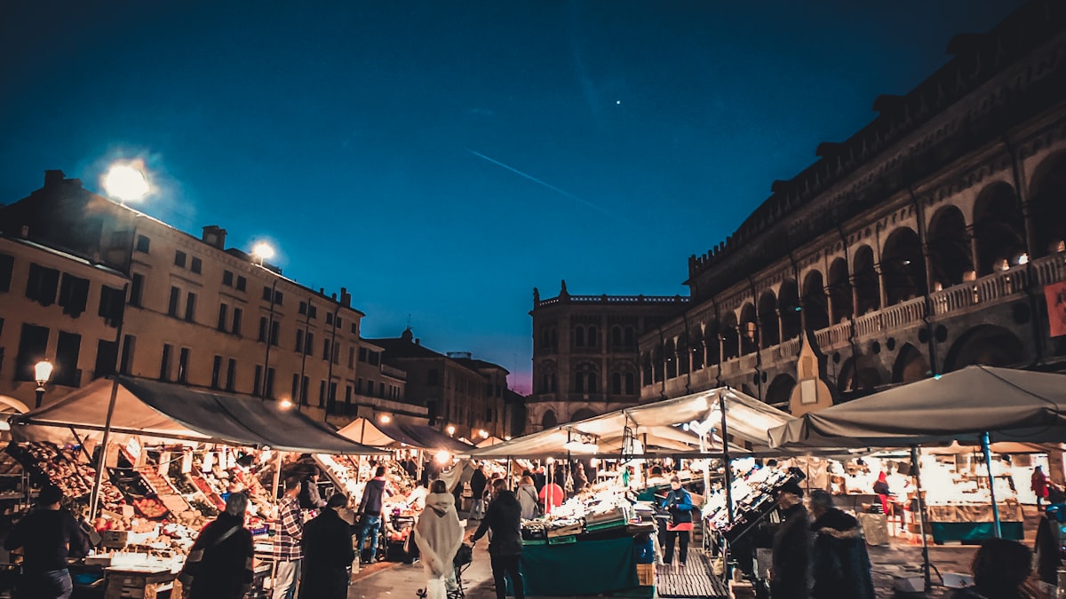 Piazza delle Erbe a Padova illuminata di sera con i portici del Palazzo della Ragione